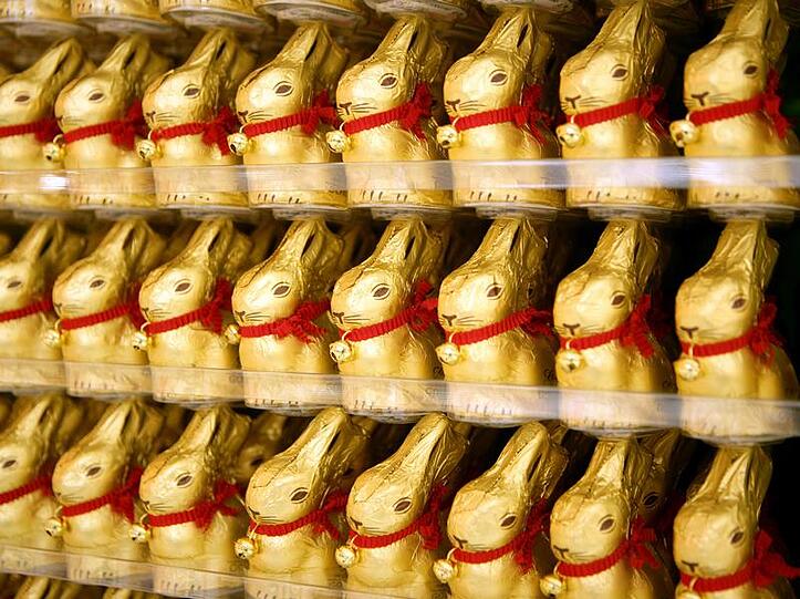 Lindt wickelt seien Schokohäschen ein rotes Halsband mit Glöckchen um den Hals, während dem Konkurrent lediglich eine bräunlich-rötliche Schleife aufdruckt.