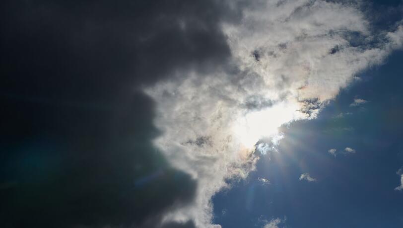 Die Sonne kommt hinter Regenwolken hervor.
