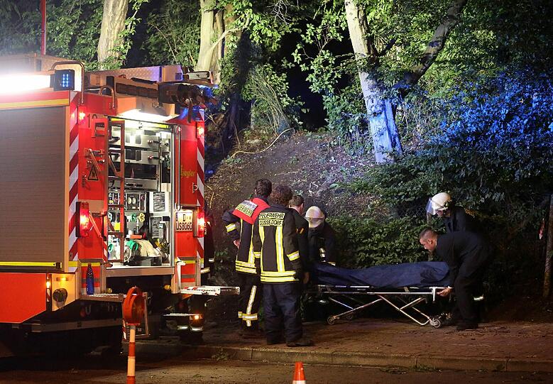 Eine Leiche wird von Feuerwehrleuten und Bestattern abtransportiert.