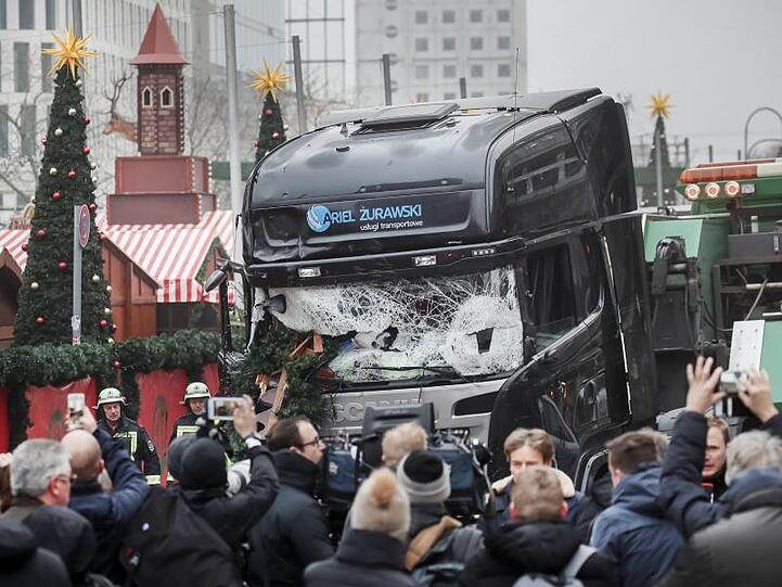 Menschen stehen vor dem LKW, mit dem ein Anschlag auf den Weihnachtsmarkt in Berlin verübt worden war (Archivbild).