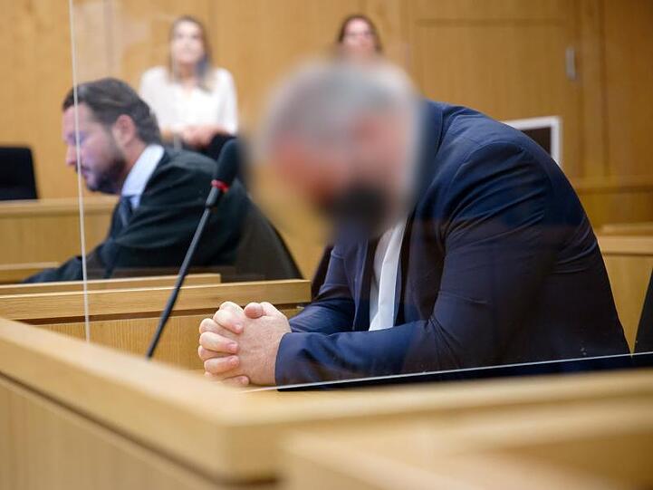 Der Angeklagte sitzt vor Beginn seines Prozesses in einem Saal des Aachener Landgerichts neben seinem Rechtsanwalt.