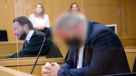 Der Angeklagte sitzt vor Beginn seines Prozesses in einem Saal des Aachener Landgerichts neben seinem Rechtsanwalt.
