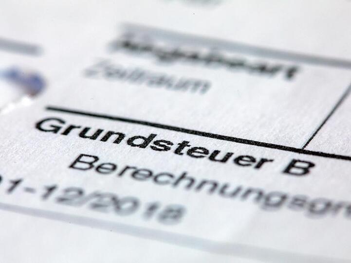 Ein Abgabenbescheid für die Entrichtung der Grundsteuer liegt auf einem Schreibtisch. Foto: Jens Büttner/zb/dpa/Archivbild