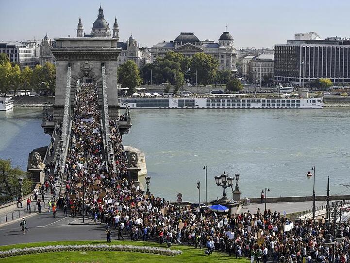 Friday-for-Future-Demonstranten ziehen in Budapest über eine Donaubrücke.