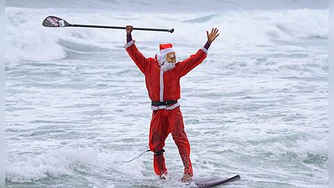 Surfende Weihnachtsmänner sieht man unter anderem in Brasilien. Dort markiert Weihnachten den Beginn des Sommers.