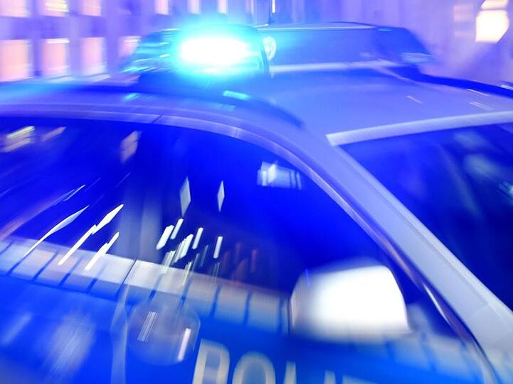 Ein Streifenwagen steht mit Blaulicht auf einer Straße. Foto: Carsten Rehder/dpa/Illustration