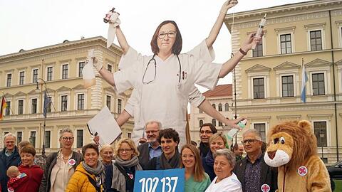 Natascha Kohnen (SPD) , Ates Gürpinar (Linke) und Pflegekräfte halten ein Schild mit der Zahl 102 137. Foto: Stefan Jagel/Archivbild