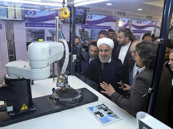 Irans Präsident Hassan Ruhani (M.) lässt sich neue Entwicklungen in der Atomenergie im Rahmen des "Nationalen Atomtags" erklären.