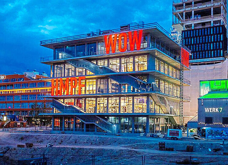 Architektur: "Werk 12" von MVRDV Das Architekturbüro mit dem sperrigen Namen MVRDV hat schon den niederländischen Pavillon für die Expo 2000 entworfen. Der gefiel Werner Eckart, dem Pfanni-Erben. Und so bekamen die Rotterdamer den Auftrag für das Werk 12. Das fasziniert durch Transparenz, Leichtigkeit und Freitreppenarchitektur &ndash; offen für verschiedene Nutzungen. Ein spektakulärer Witz sind die Comic-Ausrufe, die in Leuchtbuchstaben von der Fassade rufen (entworfen von Beate Engl und Christian Engelman): Ein Gefühlsbogen von "Hihi" über "Aahh" bis "Puh". Das &ndash; so Eckart &ndash; habe er alles in der Entstehungsphase empfunden. Wow!