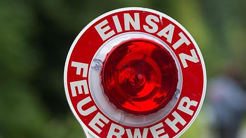 Ein Feuerwehrmann hält eine Kelle mit der Aufschrift "Einsatz Feuerwehr" in der Hand. Foto: picture alliance / dpa/Symbolbild