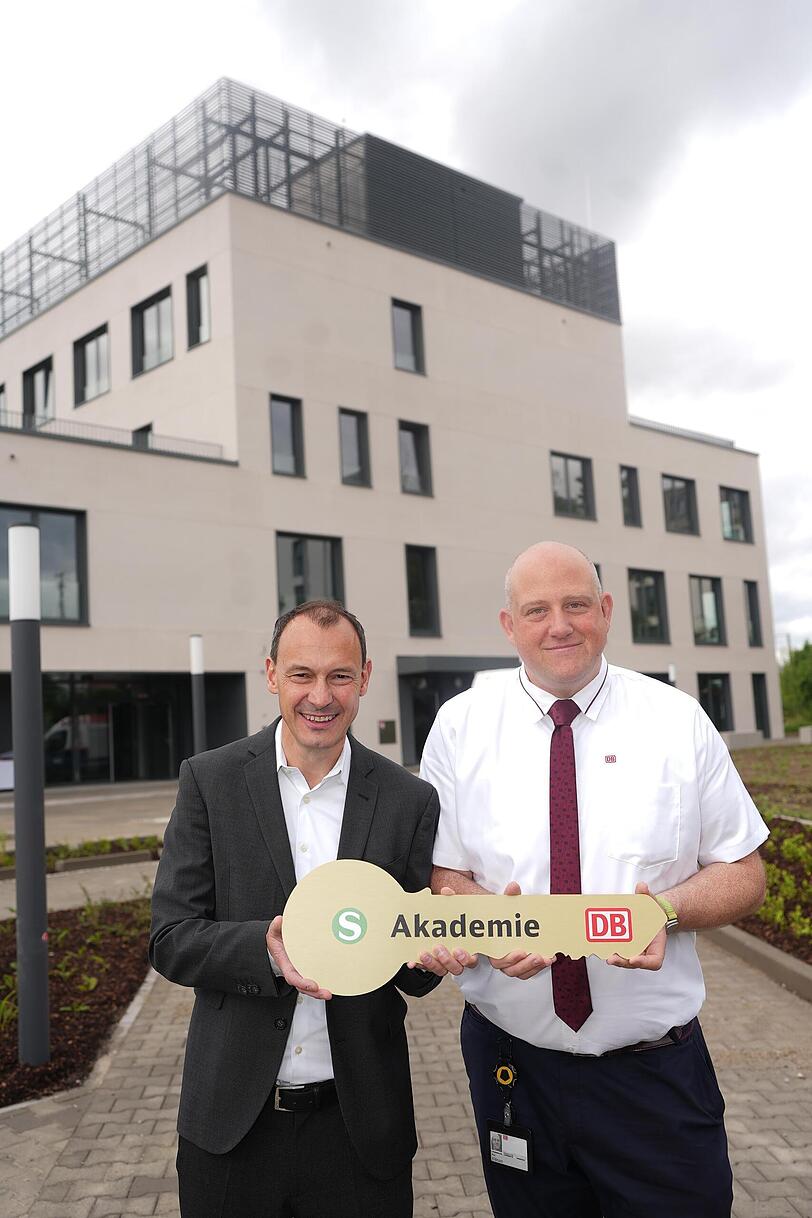S-Bahn-Chef Matthias Glaub und Akademieleiter Marc Hildmann. Im Hintergrund die neu er&ouml;ffnete Akademie f&uuml;r Lokf&uuml;hrer.