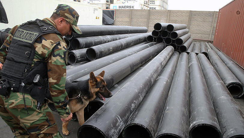 Ein Mitarbeiter des Antidrogenkommandos der peruanischen Polizei untersucht in Lima gemeinsam mit seinem Spürhund PVC-Röhren. Ein Mitarbeiter des Antidrogenkommandos der peruanischen Polizei untersucht in Lima gemeinsam mit seinem Spürhund PVC-Röhren.
