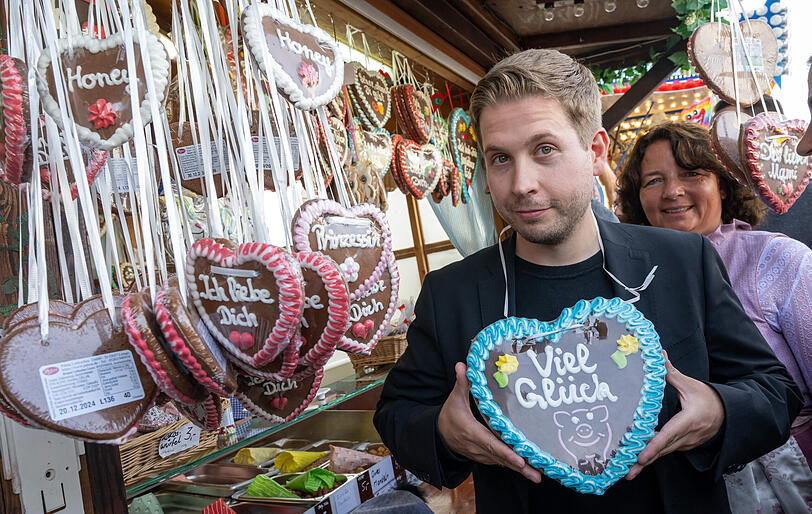 Kevin Kühnert, Generalsekretär der SPD, macht kurz Halt an einem Stand mit Lebkuchenherzen.