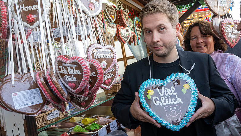 Kevin Kühnert, Generalsekretär der SPD, macht kurz Halt an einem Stand mit Lebkuchenherzen.