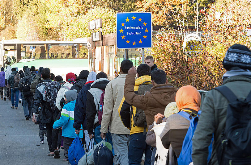 Angekommen im Land ihrer Sehnsucht: Flüchtlinge überqueren am Sonntagmorgen nahe Wegscheid (Bayern) die Grenze von Österreich nach Deutschland und steigen in einen Reisebus.