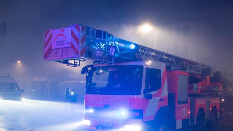Ein Einsatzfahrzeug der Feuerwehr mit Drehleiter bahnt sich in Frankfurt am Main den Weg durch die Straßen. Ein Einsatzfahrzeug der Feuerwehr mit Drehleiter bahnt sich in Frankfurt am Main den Weg durch die Straßen.