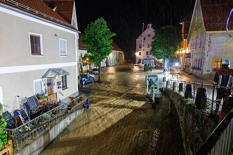 Wassermassen fließen nach starkem Regen über den Marktplatz in der Gemeinde Kastl.