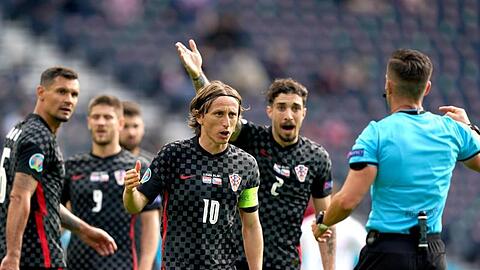 Luka Modric (M) und seine kroatischen Mitspieler reden auf Schiedsrichter Carlos del Cerro Grande (r) ein.