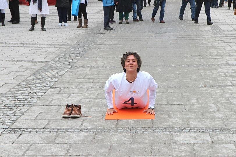 Hopsen und Dehnen in der Fußgängerzone: Am Stachus haben sich Yoga-Fans zu einem Flashmob unter freiem Himmel verabredet. Die Bilder.