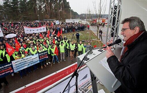 Der Bezirksleiter der IG-Metall Bayern, Jürgen Wechsler, spricht vor Beschäftigten von Cassidian, einer Tochtergesellschaft des Luft- und Raumfahrtkonzerns EADS, am 28.11.2013 vor dem Werk in Manching (Bayern) während einer Protestkundgebung gegen einen geplanten Stellenabbau.