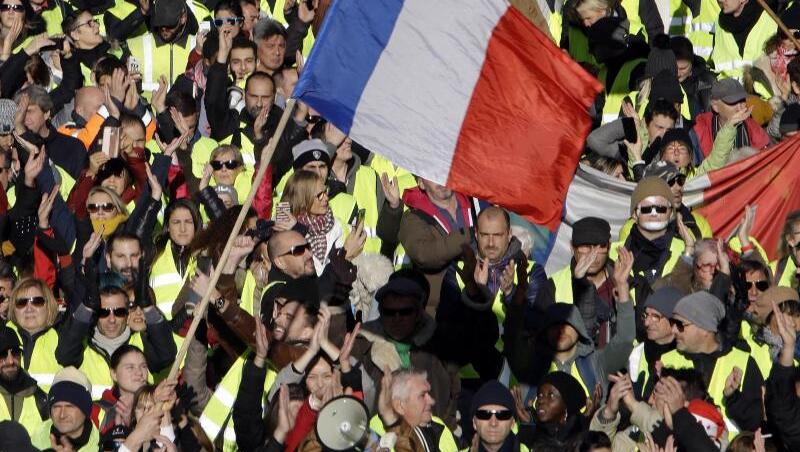 Demonstranten der "Gelbwesten" schwenken französische Fahnen während eines Protestzugs durch Marseille. Demonstranten der "Gelbwesten" schwenken französische Fahnen während eines Protestzugs durch Marseille.