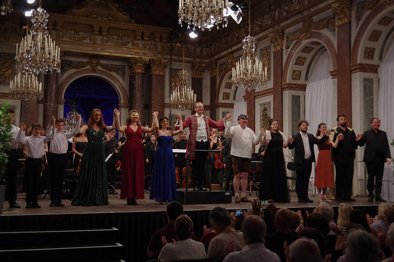 Rüdiger Lotter (Mitte) mit den Solisten und der Hofkapelle München im Spiegelsaal von Schloss Herrenchiemsee.