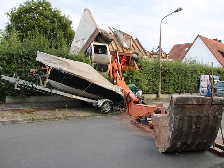 Ein Bagger liegt umgekippt auf der Straße. Foto: Andreas Eberlein