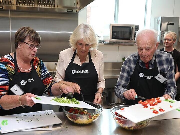 Herzogin Camilla (m.) bei einem Kochkurs mit den Köchen von "The Cooks", einem Projekt für Senioren bei der Heilsarmee.