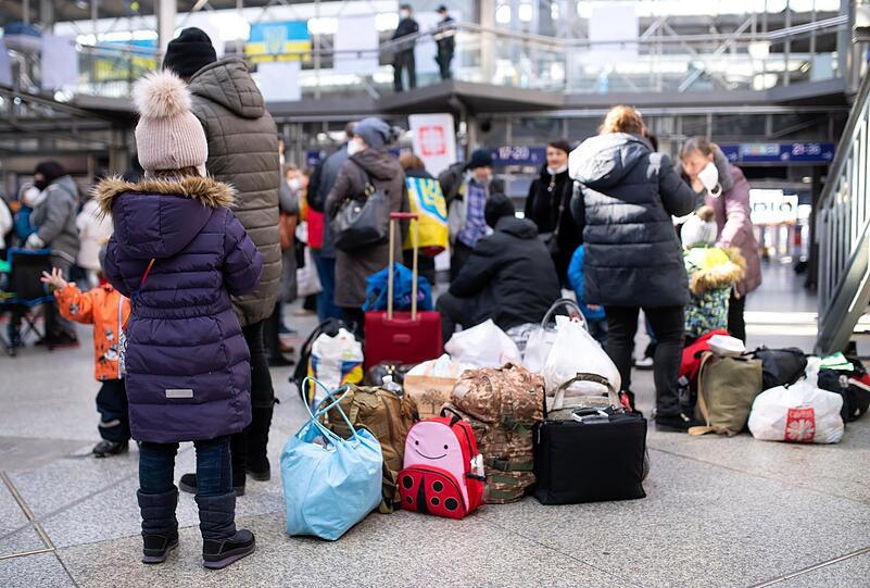 Flüchtlinge aus der Ukraine warten nach ihrer Ankunft am Hauptbahnhof in einer Halle.