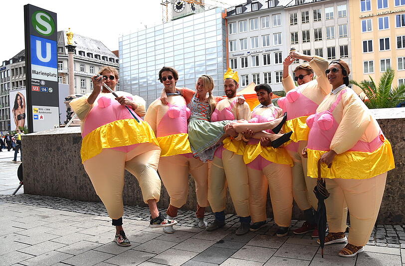 Am Ende werden sie zum Fotomotiv: Passanten scharen sich um die Junggesellen, die sich vor der Calzedonia-Werbung am Marienplatz prächtig amüsieren.