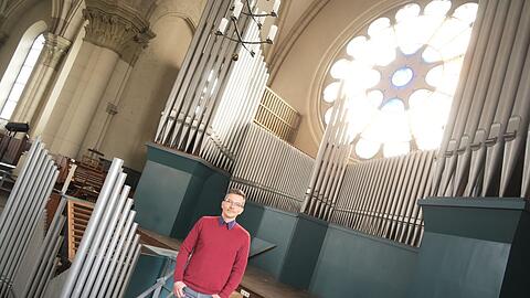 Frank vor der Orgel in St. Lukas. Im Hintergrund ist der ausgediente Spieltisch zu sehen.