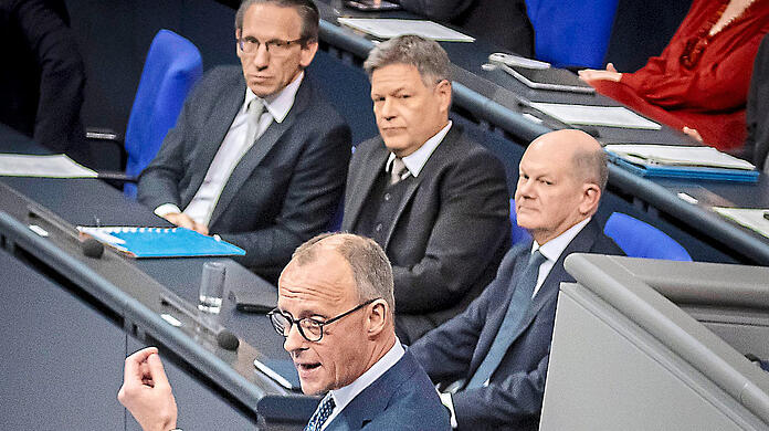 Bundeskanzler Olaf Scholz hört mit Robert Habeck (h. M.) eine Rede des CDU-Chefs Friedrich Merz an.