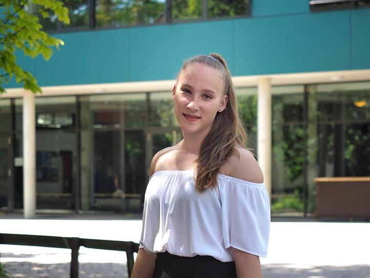 Niedersachsens jüngste Abiturientin Mandy Hoffmann steht mit Blumen in der Hand vor ihrer Schule. Mandy hat mit 14 Jahren das Abitur mit der Note 1,0 bestanden.