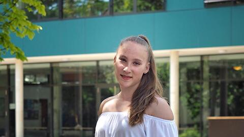 Niedersachsens jüngste Abiturientin Mandy Hoffmann steht mit Blumen in der Hand vor ihrer Schule. Mandy hat mit 14 Jahren das Abitur mit der Note 1,0 bestanden.