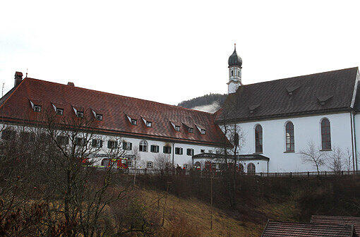 Einsatzkräfte der Feuerwehr stehen am Sonntagmorgen vor dem Franziskanerkloster in Füssen.