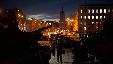 Eine Frau steht vor einer Ausstellung zerstörter russischer Panzer und gepanzerter Fahrzeuge in der Kiewer Innenstadt.