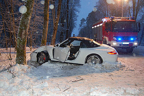 Dieser weiße Porche prallte auf schneeglatter Straße gegen einen Baum.