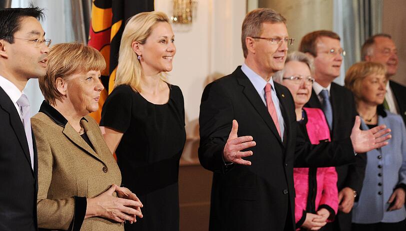 Während des Neujahrsempfangs im Schloss Bellevue in Berlin stellen sich am Donnerstag (12.01.2012) Wirtschaftsminister Phillip Rösler (l-r, FDP), Bundeskanzlerin Angela Merkel (CDU), Bettina Wulff, Bundespräsident Christian Wulff, Bundesbildungsministerin Annette Schavan (CDU), Kanzleramtschef Ronald Pofalla (CDU), Integrationsbeauftragte Maria Böhmer (CDU) und Kulturstaatsminister Bernd Neumann (CDU) zu einem Gruppenfoto auf.