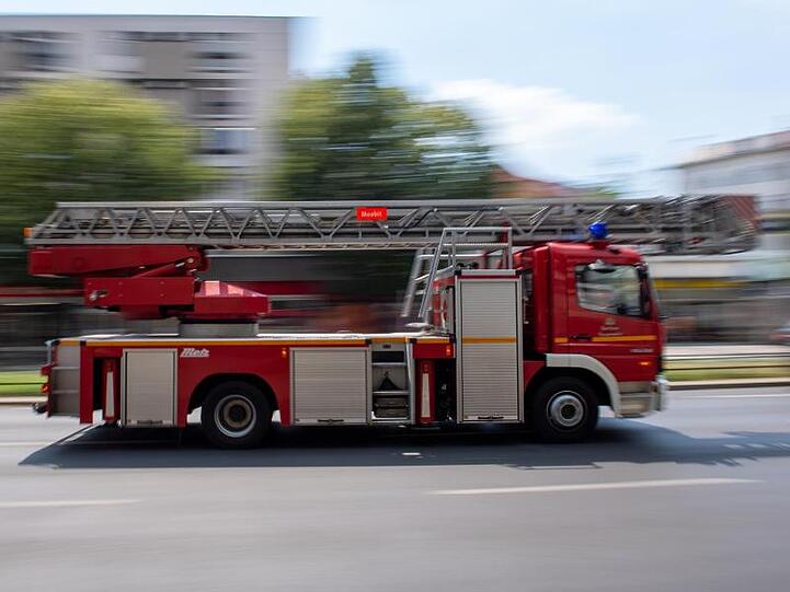 Ein Feuerwehrauto fährt mit Blaulicht zu einem Einsatz. Foto: Monika Skolimowska/zb/dpa/Archivbild