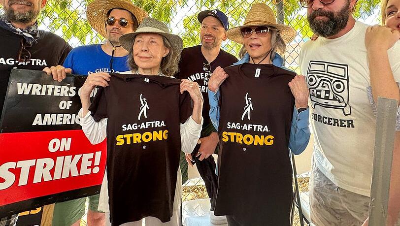 Lily Tomlin (l.) und Jane Fonda halten ihre Streik-Shirts in die Kamera.