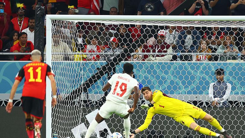 Belgiens Torwart Thibaut Courtois (r) hält den Strafstoß des Kanadiers Alphonso Davies (M/19).