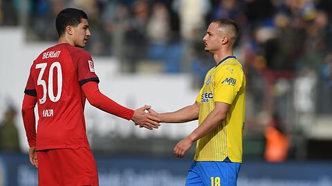 Braunschweigs Marvin Rittmüller (r) und der Berliner Ibrahim Maza klatschen sich nach dem 1:1 ab.