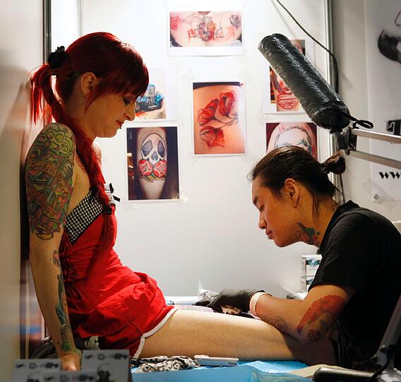 Auch diese Frau lässt sich ein weiteres Tattoo stechen.