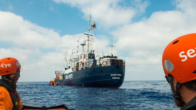 Zwei Seenotretter vor dem Rettungsschiff "Alan Kurdi". Zwei Seenotretter vor dem Rettungsschiff "Alan Kurdi".