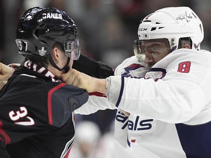 Alexander Owetschkin (r) von Washington Capitals und Andrej Swetschnikow von Carolina Hurricanes prügeln sich auf dem Eis.