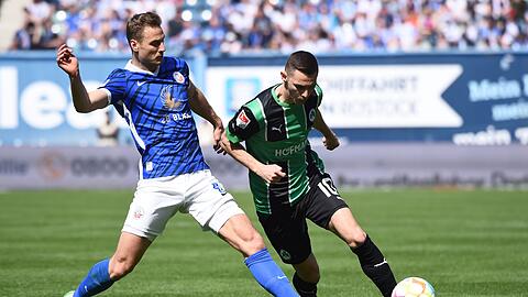 Rostocks Dennis Dressel (l-r) versucht Fürths Branimir Hrgota den Ball abzunehmen.