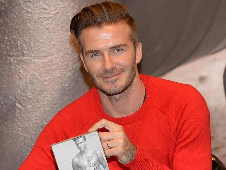 David Beckham mit einer Autogrammkarte zu seiner aktuellen Unterwäsche-Kollektion