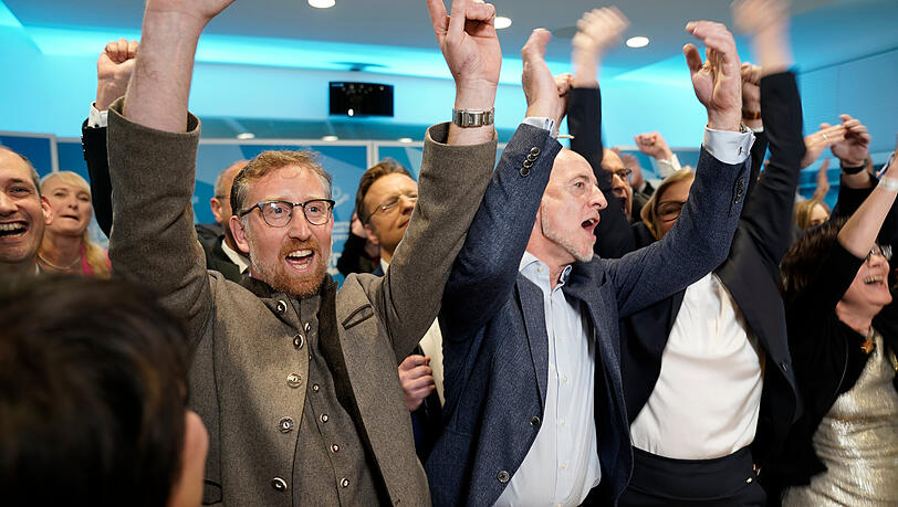 Andreas Winhart (l), Parlamentarischer Geschäftsführer der AfD, Spitzenkandidat Martin Böhm und Katrin Ebner-Steiner (r, verdeckt) feiern bei der Wahlparty der AfD nach der Wahl zum 19. Bayerischen Landtag die erste Prognose.