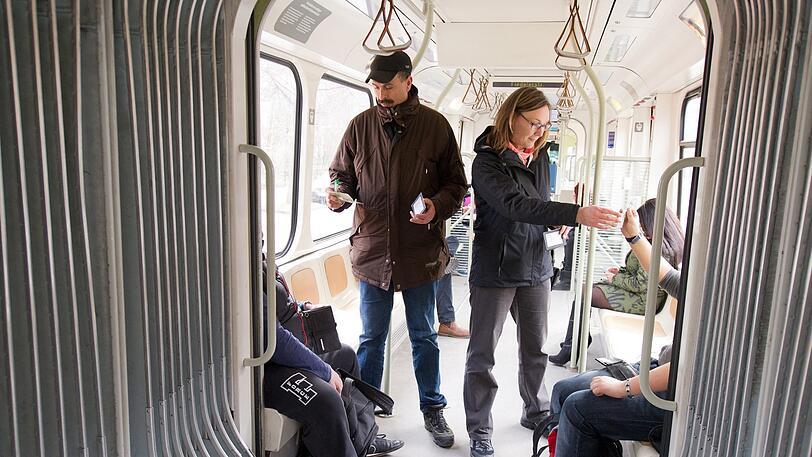 Kontrolleure überprüfen die Tickets der Fahrgäste.