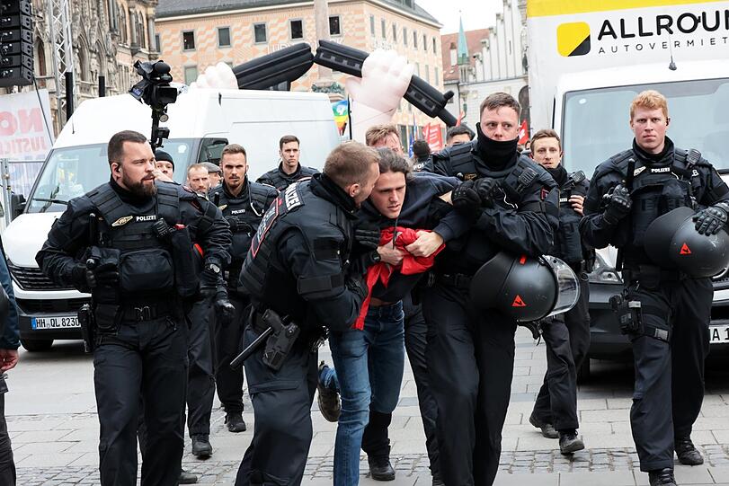 Polizisten führen bei der Schlusskundgebung des linken Friedensbündnisses am Marienplatz einen Demonstranten ab.